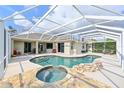 Beautiful screened-in pool with waterfall, integrated spa, spacious patio, and manicured lawn at 3309 45Th E Ave, Bradenton, FL 34203