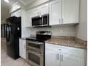 Modern kitchen features white cabinets, stainless steel appliances, granite countertops, and ample storage at 3600 Wisteria Pl, Punta Gorda, FL 33950