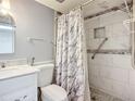Bathroom featuring marble tiled shower with pebble floor, marble vanity and a decorative shower curtain at 3702 Lake Bayshore K-412 Dr # 412, Bradenton, FL 34205