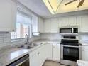 Bright kitchen features white cabinets, stainless steel appliances, and a window with a view at 3702 Lake Bayshore K-412 Dr # 412, Bradenton, FL 34205