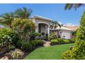 Single-story home with an arched entryway, tidy landscaping and green lawn on a sunny day at 3806 72Nd E Ter, Sarasota, FL 34243