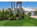 Single-story home features a white tiled roof and meticulously maintained lawn with decorative landscaping at 3806 72Nd E Ter, Sarasota, FL 34243