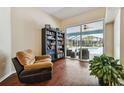 Cozy living room featuring a sliding glass door to the screened-in pool area and wood-look floors at 3919 Fan Palm Ct, Land O Lakes, FL 34638