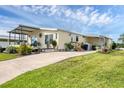 Well-maintained home with a covered porch, a cozy patio area, and a lush green lawn at 4119 13Th E St, Ellenton, FL 34222