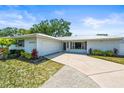 Beautifully landscaped single-story home with a new metal roof, lush landscaping, and an attached two-car garage at 4425 Parnell Dr, Sarasota, FL 34232