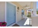 Charming covered front porch with blue door, rocking chairs and bright potted flowers at 4811 Woodbrook Dr, Sarasota, FL 34243