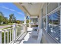 Inviting front porch featuring a ceiling fan, white railings, and comfortable Adirondack chairs at 4811 Woodbrook Dr, Sarasota, FL 34243
