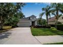 Charming single-Gathering home featuring a well-manicured lawn, mature palm trees, and a two-car garage at 5036 Brickell Park Cv, Bradenton, FL 34211