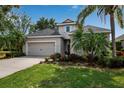Charming single-Gathering home featuring a well-manicured lawn, mature palm trees, and a two-car garage at 5036 Brickell Park Cv, Bradenton, FL 34211