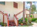 Exterior stairs leading to condo entrance, surrounded by lush landscaping at 523 Spring Lakes Blvd, Bradenton, FL 34210