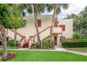 Attractive condo building with exterior stairs, colorful plants, and well-manicured lawn at 523 Spring Lakes Blvd, Bradenton, FL 34210