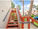 Outdoor condo staircase with wooden railings and lush greenery at 523 Spring Lakes Blvd, Bradenton, FL 34210