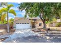 Charming one-story home featuring an attached garage, mature landscaping, and a welcoming front porch at 5623 Wilde Oak Way, Sarasota, FL 34232