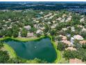 Aerial view of a residential community featuring tree-lined streets and a tranquil lake, offering a peaceful setting at 5729 Garden Lakes Palm, Bradenton, FL 34203