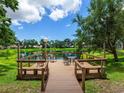 Inviting wooden dock on a serene lake, furnished for relaxation with seating and lighting at 5729 Garden Lakes Palm, Bradenton, FL 34203
