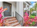 Inviting front entry with brick steps, black railings, tropical plants, and a 'welcome' sign at 5823 Title Row Dr, Bradenton, FL 34210
