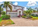 Home exterior with well-maintained landscaping, a paver driveway, and a two-car garage door at 5823 Title Row Dr, Bradenton, FL 34210