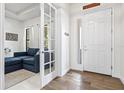 Bright foyer showcasing light wood flooring, a white front door with glass, and a glimpse into a living room at 5823 Title Row Dr, Bradenton, FL 34210