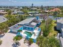 Aerial view of the home showing the outdoor pool, landscaping, and neighboring properties near the waterway at 5920 Gulf Of Mexico Dr, Longboat Key, FL 34228