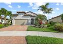 Beautiful home featuring a well maintained lawn, elegant landscaping, and a brick driveway at 5987 Snowy Egret Dr, Sarasota, FL 34238