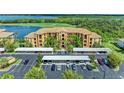 Exterior front view of a condo building featuring ample parking, palm trees, and lush landscaping at 6519 Grand Estuary Trl # 107, Bradenton, FL 34212