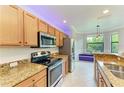 Bright kitchen with stainless steel appliances, granite countertops and a breakfast nook with a view at 6519 Grand Estuary Trl # 107, Bradenton, FL 34212