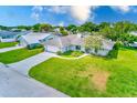 Aerial view of a white single-Gathering home on a large lot, with a big front yard and mature trees at 6627 Heritage Ln, Bradenton, FL 34209
