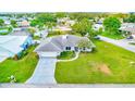 An aerial view shows the house and its surroundings in a neighborhood with lush green lawns at 6627 Heritage Ln, Bradenton, FL 34209