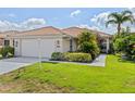 Charming single-story home with a tile roof, well-manicured lawn, and lush tropical landscaping at 6764 Hickory Hammock Cir, Bradenton, FL 34202