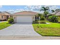 Charming single-story home with a tile roof, well-manicured lawn, and lush tropical landscaping at 6764 Hickory Hammock Cir, Bradenton, FL 34202