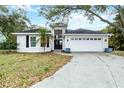 Charming single-story home featuring a manicured lawn, a two-car garage, and classic curb appeal at 7 Arbor Oaks Dr, Sarasota, FL 34232
