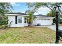Charming single-story home featuring a manicured lawn, a two-car garage, and classic curb appeal at 7 Arbor Oaks Dr, Sarasota, FL 34232