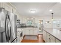 Bright kitchen features stainless steel appliances, white cabinetry, mosaic backsplash, and durable countertops at 720 S Green Cir, Venice, FL 34285