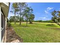 A lush green backyard view featuring manicured lawns and mature trees at 7637 Sweetbay Cir, Bradenton, FL 34203