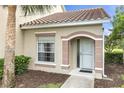The front entrance of the home features a white door, beige trim, and a view of the yard at 7637 Sweetbay Cir, Bradenton, FL 34203