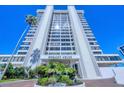 Exterior view of Embassy House, featuring a tall, modern condo building with lush landscaping at 770 Palm Avenue # 903, Sarasota, FL 34236