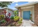 Close up of home's blue double door entrance and walkway with brick columns and lush landscaping at 7984 Glenbrooke Ln, Sarasota, FL 34243
