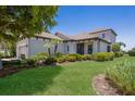 Well-maintained home with mature tree, lush lawn, and landscaped flower beds at 8191 Gabanna Dr, Sarasota, FL 34231