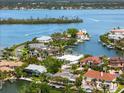 Aerial view showing waterfront homes on canals with mature trees, docks and boat lifts at 868 Siesta Key Cir, Sarasota, FL 34242