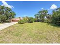 Spacious front lawn and driveway leading to a two-car garage in a serene setting at 911 Cimarron Cir, Bradenton, FL 34209