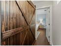 Hallway with wood floors featuring a striking barn door leading to a bedroom at 911 Cimarron Cir, Bradenton, FL 34209
