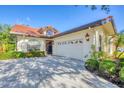 Stylish single-story home featuring a red tile roof, well-maintained landscaping, and a two-car garage at 4517 Las Brisas Ln, Sarasota, FL 34238