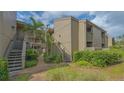 Condo building exterior with well-maintained landscaping and stairs leading to upper units at 107 Woodland Pl # 107, Osprey, FL 34229