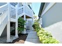 A paved walkway leads between condo buildings with lush green landscaping, and stairs leading up to the second floor entrance at 1226 Siesta Bayside Dr # 1226C, Sarasota, FL 34242