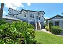 Beautiful two-story condo building with lush greenery, a well-manicured lawn, and white stairs leading to the entrance at 1226 Siesta Bayside Dr # 1226C, Sarasota, FL 34242