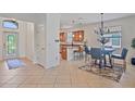 Bright dining area featuring modern chandelier, tile floors and kitchen bar access at 148 Wandering Wetlands Cir, Bradenton, FL 34212
