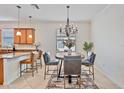 Eat-in kitchen dining area with chandelier, breakfast bar, and backyard view at 148 Wandering Wetlands Cir, Bradenton, FL 34212