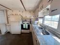 Cozy kitchen featuring white cabinets, a stainless steel sink, and standard appliances at 237 Blackburn Blvd, North Port, FL 34287