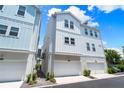 Rear elevation of townhome with a two-car garage and white siding at 2408 Ezzell Ct, Sarasota, FL 34237