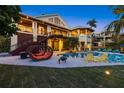 Luxury home with a gorgeous pool, ample seating, a manicured lawn and a backyard designed for entertainment at 26 Sandy Hook S Rd, Sarasota, FL 34242